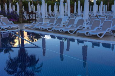 Alanya, Türkiye - 05 Ekim 2018. Kirman Sidera lüks otel ile güzel havuzu temiz deniz, mavi gökyüzü ve yeşil palmiye ağaçları zemin üzerine mavi su. Plaj şezlong, yaz tatili, turizm