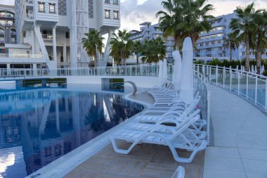 Alanya, Türkiye - 05 Ekim 2018. Kirman Sidera lüks otel ile güzel havuzu temiz deniz, mavi gökyüzü ve yeşil palmiye ağaçları zemin üzerine mavi su. Plaj şezlong, yaz tatili, turizm