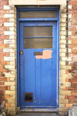 Rustik kapı kapalı geliyor boya ile yamalı tuğla duvara kediler kapıyı flep ile. İngilizce kırsal