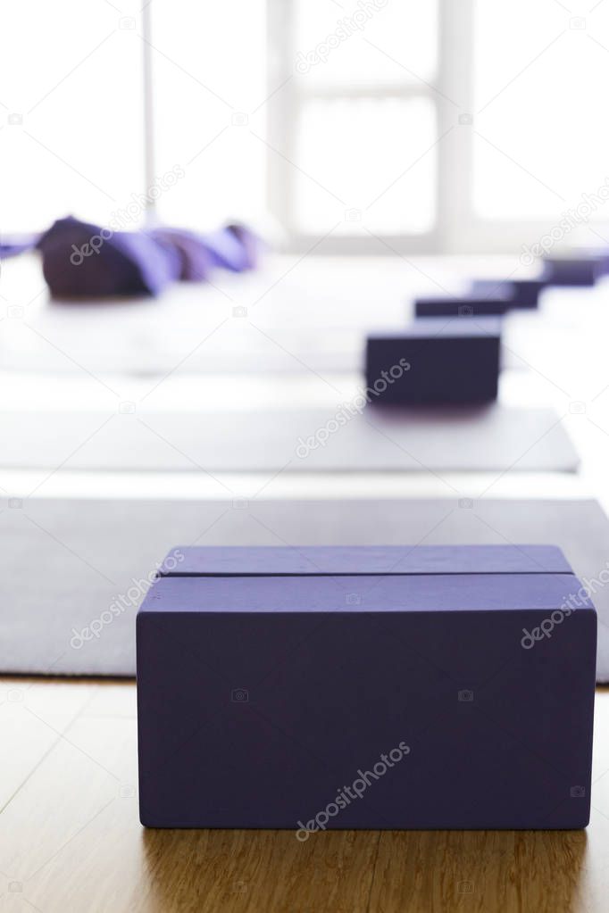 Empty, bright Yoga studio with mats and foam blocks. Wooden floor.