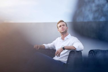 Güven unutmayın. Sandalyede oturan ve thinkign geleceğiyle ilgili süre seyir yakışıklı düşünceli adam