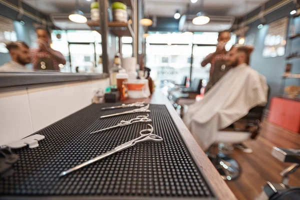 必要なツールです プロの美容師が彼のクライアントの髪をカットしながらテーブルの上に横たわる美容機器のクローズ アップ — ストック写真