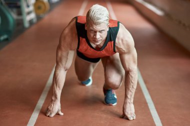 Önemli yarış. Dört gözle ise kendinden emin profesyonel erkek sprinter duran bir başlangıç konumu üzerinde Kapat