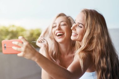İki bayan arkadaşlar zaman birlikte selfie çekim için sosyal medya neşeli yakın çekim gülüyor Smartphone'da ayakta dışında yürüyüş