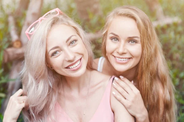 Two Female Friends Time Together Standing Floral Background Hugging Looking — Stock Photo, Image