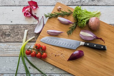 Bir kesme tahtası ahşap arka plan en iyi manzaralı bıçak sağlıklı gıda - sebze, soğan, salata, domates, patates ile yerleştirilen
