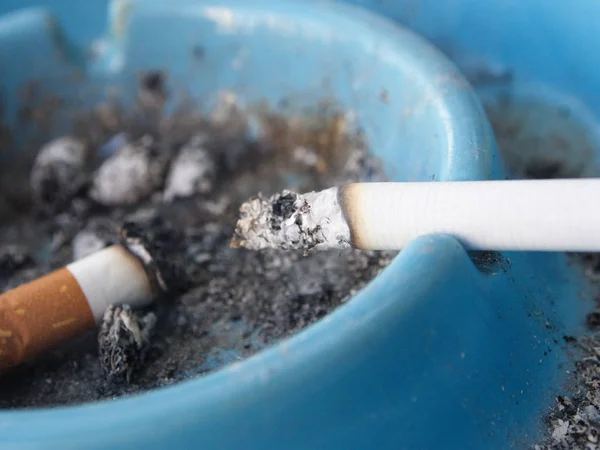 Aschenbecher und Zigarette. ein Raucherraum mit Holztisch — Stockfoto