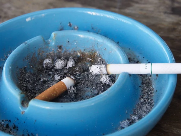 Cinzeiro e cigarro. um lugar para fumar com uma mesa de madeira — Fotografia de Stock