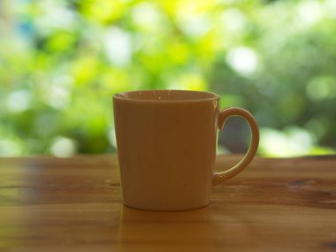Yeşil yaprak bokeh ile Closeup Beyaz Cofee Kupası.