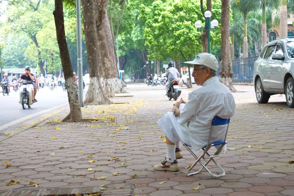 O velho vietnamita estava sentado na cadeira. Sozinho com a árvore — Fotografia de Stock