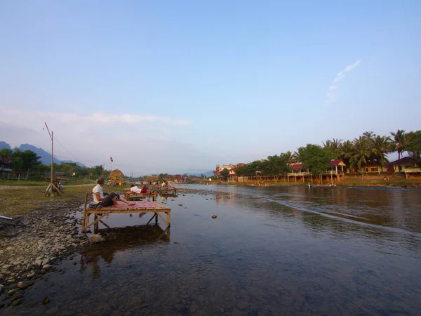 Puesta de sol en Riverside con fondo de montaña, Viajar en Vang Vi —  Fotos de Stock