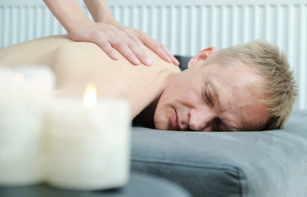 Health massage therapy. Female hands are massaging the back of a man.