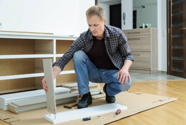 Komodinin montaj. Adam çekmeceyi parçalarını birleştiren hattır.