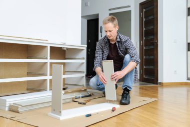 Komodinin montaj. Adam çekmeceyi parçalarını birleştiren hattır.