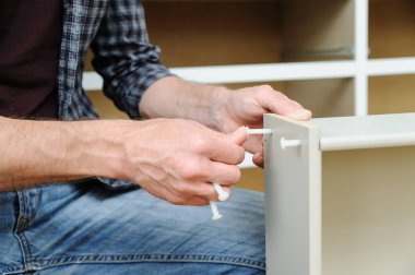 Komodinin montaj. Bir adam çekmeceyi parçalarını birleştiren hattır.