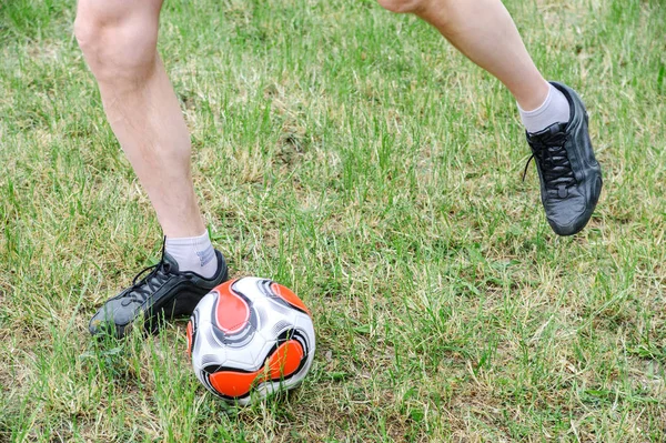 Football game. A man out of a swing strikes a ball.