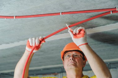 Elektrikçi elektrik bir oluklu boru tavana sabitleme.