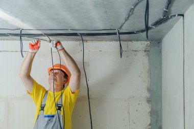 Elektrikçi elektrik kabloları tavana sabitleme.