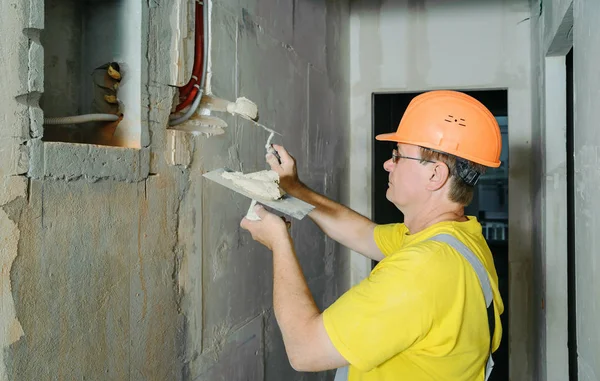 Працівник Тримає Кельми Гіпсом Він Покриває Електричні Гофровані Труби Стіні — стокове фото