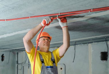 Elektrikçi elektrik bir oluklu boru tavana sabitleme.