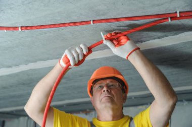Elektrikçi elektrik bir oluklu boru tavana sabitleme.