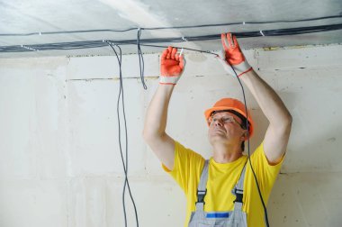 Elektrikçi elektrik kabloları tavana sabitleme.