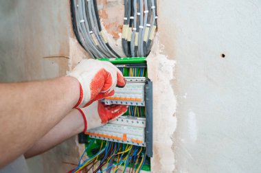 Sigortalar anahtarı kutusunda yükleme bir elektrikçi.