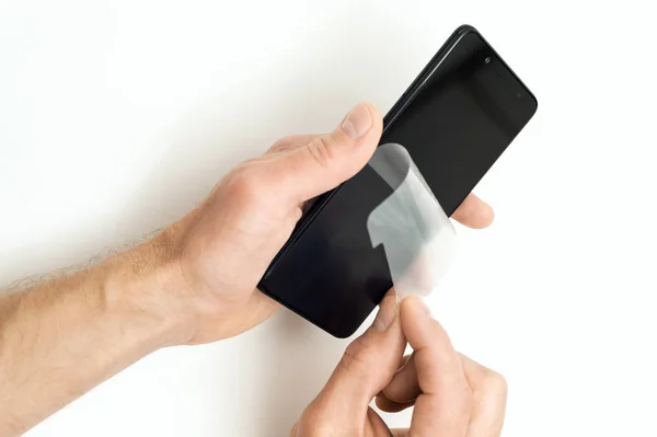 Menschliche Hände Entfernen Eine Schutzfolie Vom Bildschirm Eines Smartphones — Stockfoto