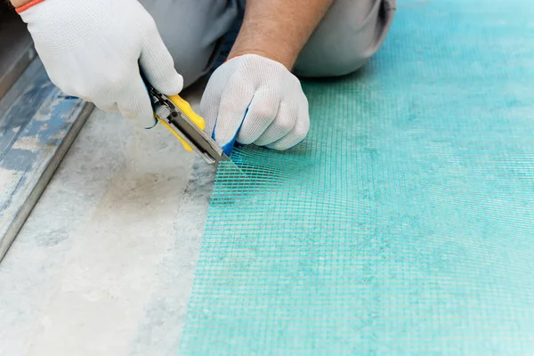 Ein Arbeiter Schneidet Mit Einem Messer Ein Stück Glasfasernetz — Stockfoto