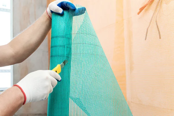 Ein Arbeiter Schneidet Mit Einem Messer Ein Stück Glasfasernetz — Stockfoto