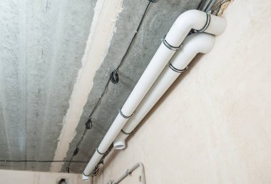 Plastik havalandırma boruları beton tavana sabitlenmiş.