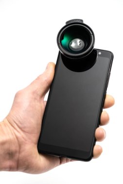 İnsan eli bağlı dış lens ile bir akıllı telefon tutuyor.
