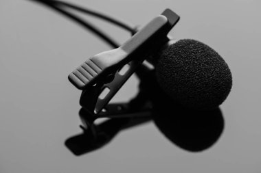 Yaka mikrofonu koyu parlak yüzey üzerinde bir kravat-klibi.