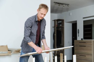 Adam mobilya evde toplanır. Komodinin kenarındaki ayarlar.