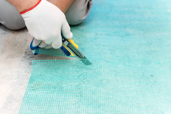 Ein Arbeiter Schneidet Mit Einem Messer Ein Stück Glasfasernetz — Stockfoto