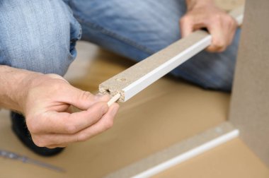 Bir adam evde mobilya montaj.