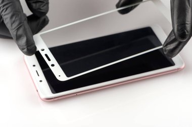 Bir adam bir smartphone üzerinde koruyucu bir cam tutuyor
