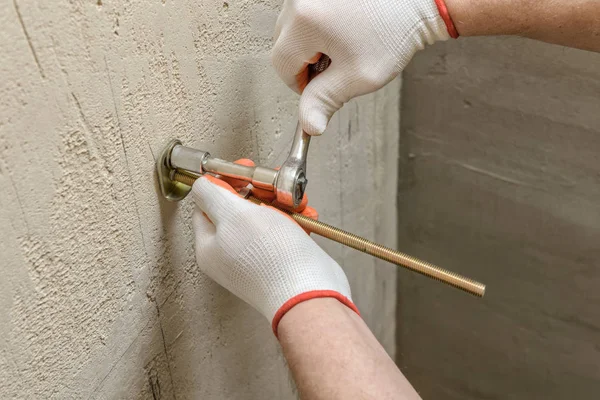 Um trabalhador está consertando uma parede de parafusos . — Fotografia de Stock