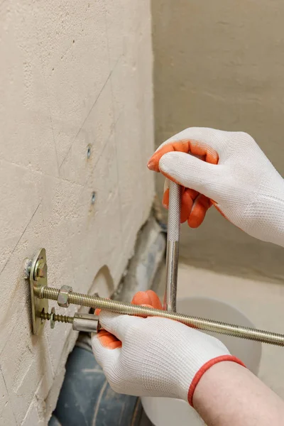 Een werknemer is het repareren van een muur van bouten. — Stockfoto