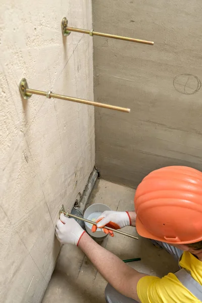 De werknemer is het repareren van een muur van bouten. — Stockfoto