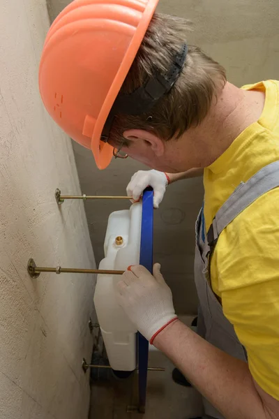 L'operaio sta montando un serbatoio del water incorporato . — Foto Stock