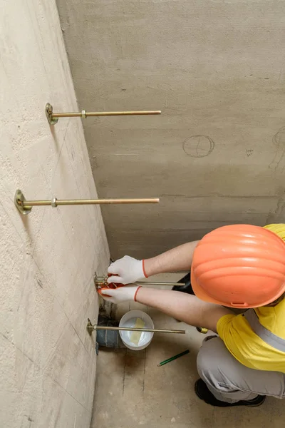 Le travailleur répare un mur de boulons . — Photo