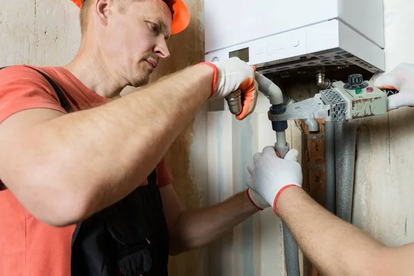 Der Arbeiter lötet die Gaskesselrohre. — Stockfoto