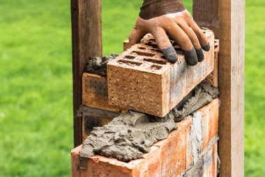 Bir işçi havan topuna tuğla koyuyor..