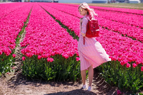 Sorrindo adolescente menina caminha através de campo de tulipa — Fotografia de Stock