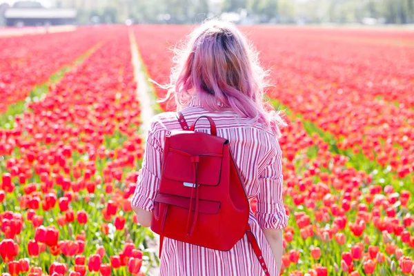 Sorrindo adolescente menina caminha através de campo de tulipa — Fotografia de Stock