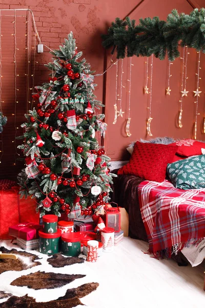Christmas, New year interior with red brick wall background, decorated Christmas tree with garlands and balls