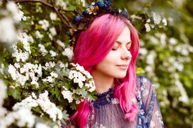 pembe saçlı ayakta yakınındaki çiçek güzel bir kızla portresi. kameraya bakarak hassasiyet modeli