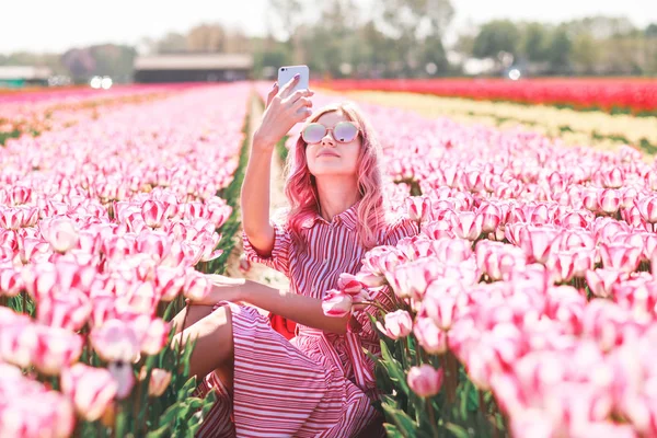 Genç kadın giyim güneş gözlüğü selfie güneşli bahar günü Lale çiçek alanında yapılır. Daha az, Hollanda