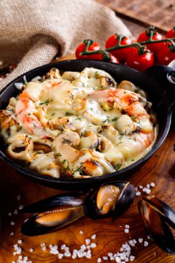 Siyah metal bir plaka üzerinde beyaz soslu lezzetli deniz ürünleri. Üstten Görünüm